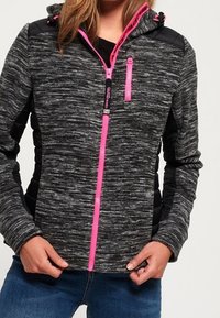 Sweat à capuche zippé chiné noir et gris avec des accents roses, une capuche à cordon, et des panneaux noirs sur les épaules et les côtés.