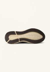 Schoenzool met een textuur van rubber en een gepatternde loop in donkerbruin. De tussenzool is crèmekleurig, wat contrasteert met de zool.
