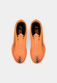 Coppia di scarpe sportive Puma di un arancione vivido con accenti neri e argento, stringhe annodate, viste dall'alto su sfondo bianco.