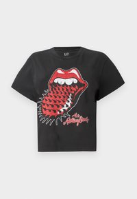 Black cotton crop t-shirt featuring a red and white graphic of lips with fangs and tongue, printed text "the Rolling Stones" below.