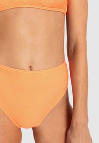 Visok pas bikini spodnji del v svetlo oranžni barvi, izdelan iz gladkega, raztegljivega materiala. Ravni šivi in minimalističen dizajn povečujeta udobje in prileganje.