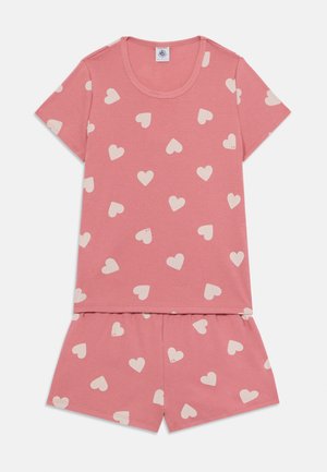 Short-sleeve pink pajama set made of soft cotton. Top features scattered cream heart patterns; shorts have matching design and elastic waistband.