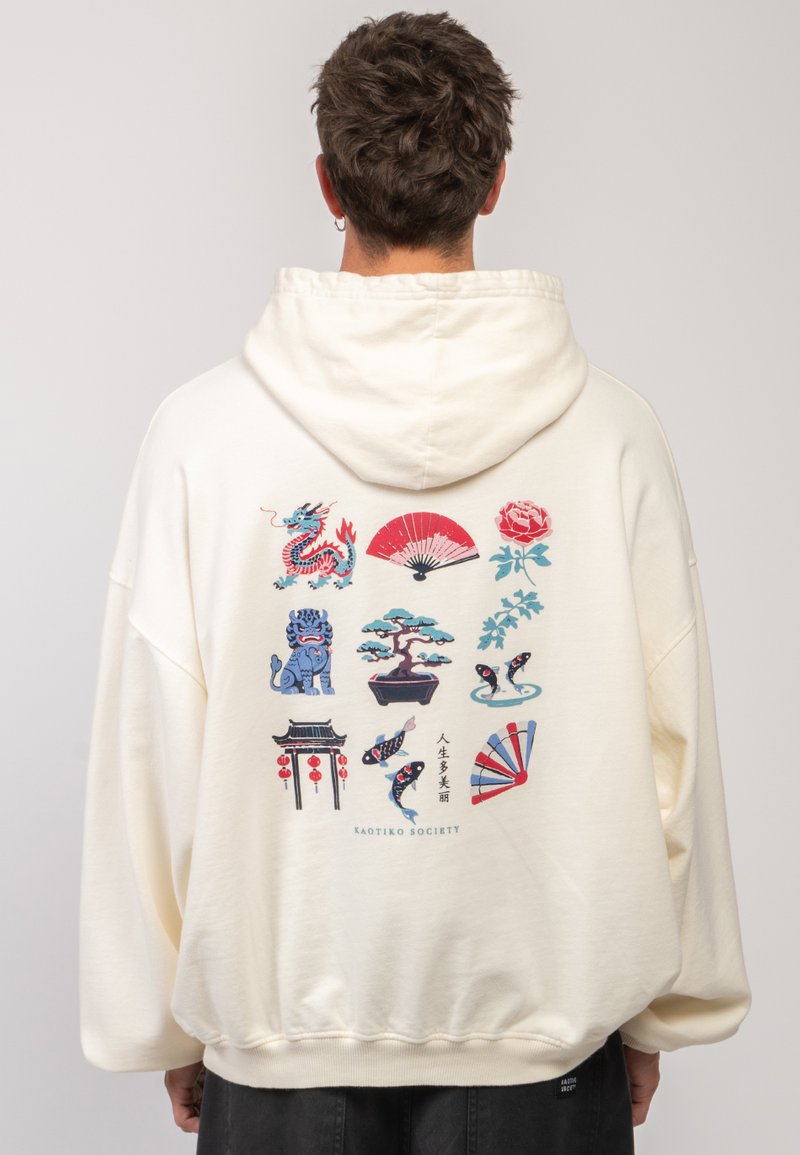 Cremefarbener Hoodie mit bunten Grafikdesigns auf der Rückseite, darunter ein Drache, ein Fächer, Blumen und verschiedene ornamentale Motive.