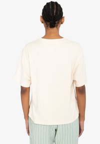 Lichtbeige katoenen t-shirt met een relaxte pasvorm en korte mouwen. Heeft een ronde halslijn en een gladde textuur.
