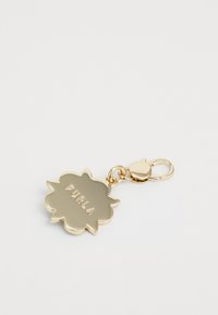 Porte-clés en métal doré avec un charm en forme de fleur gravé "FURLA" et une attache à ressort.