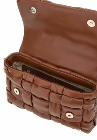 Sac à main en cuir matelassé marron avec une texture douce ; comporte une fermeture magnétique et une poche zippée à l'intérieur.