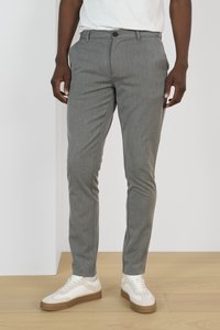 Grijze, gestructureerde broeken hebben een rechte snit en een knoopsluiting. Gecombineerd met witte sneakers met een tan kleurige zool.