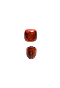 Zwei Glasperlen in Bernsteinfarbe. Die obere Perle ist quadratisch mit abgerundeten Kanten, während die untere Perle oval geformt ist. Beide sind durchsichtig.