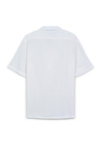 Chemise blanche à manches courtes avec une coupe décontractée, présentant un col et un tissu texturé. Design simple, sans motifs ni détails visibles.