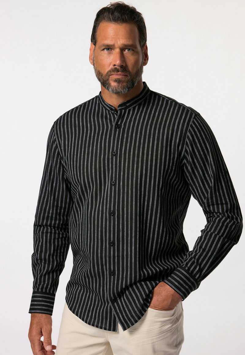 Camisa negra de manga larga con rayas verticales blancas, con botones en la parte delantera y cuello mandarín. El tejido parece texturizado. Sin patrones ni logotipos visibles.