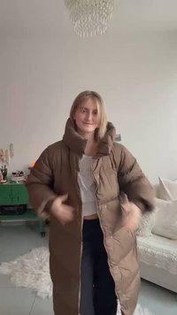 Pruun padiistmega jakk kõrge kraega, millel on tikitud muster ja nööpkinnitused. Keskmise pikkusega, valmistatud pehmest, tekstuuriga kangast.