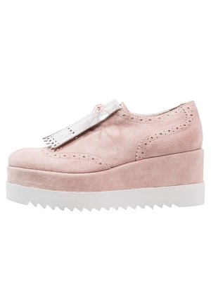 Chaussures à plateforme en suède rose avec un bout arrondi, dotées de détails en wingtip et d'une semelle blanche à crans. Accentuées d'un gland en argent.