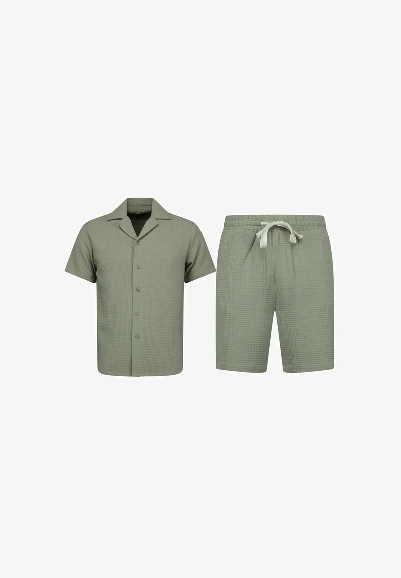 Korte mouw blouse met knopen en korte broek met trekkoord van gestructureerde olijfgroene stof, getoond op een witte achtergrond.