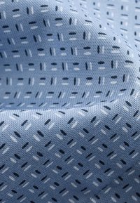 Tessuto azzurro chiaro con un motivo testurizzato di linee e trattini diagonali blu scuri e bianchi, che mette in evidenza un sottile dettaglio tessuto.