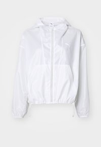 Biała krótka kurtka przeciwwiatrowa z suwakiem z przodu, ściągaczem u dołu i logo na lewej piersi. Gładka, błyszcząca tekstura.