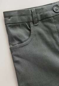 Pantaloni grigi realizzati in tessuto liscio, con chiusura a bottoni e tasca frontale con dettagli cuciti.