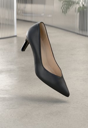 Schwarzer Leder-High-Heel-Schuh mit spitz zulaufender Zehenpartie und schlankem Profil, ausgestattet mit einem niedrigen Absatz und einem weichen Innenfutter.