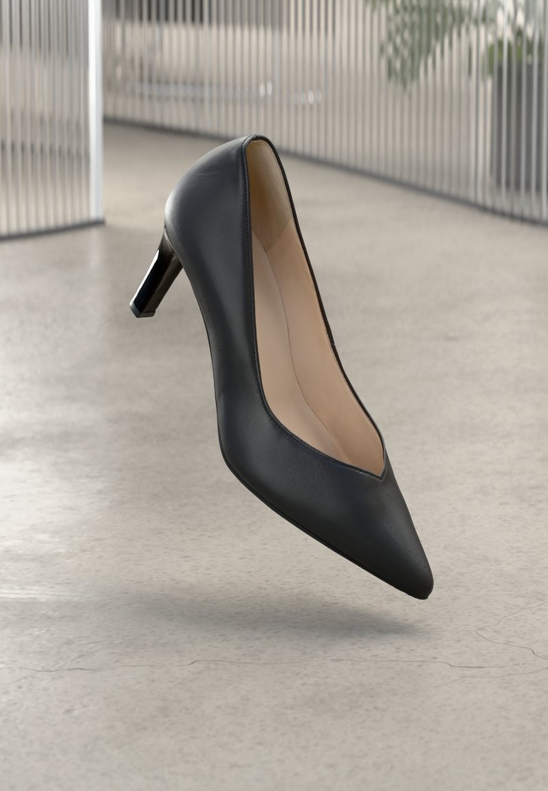 Zwarte leren hoge hak schoen met een spitse neus en een slanke silhouet, met een lage hak en een zachte binnenvoering.