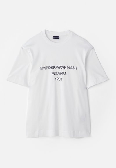 Valge puuvillane t-särk lühikeste varrukatega, millel on tumesinise kirjatükiga "EMPORIO ARMANI MILANO 1981" ja logo. Klassikaline ümmargune kaelus.