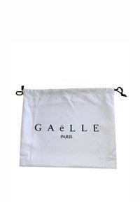 Borsa a tracolla bianca realizzata in tessuto, con la scritta "GAëLLE PARIS" in lettere nere in grassetto. Accentuata con cordini neri.
