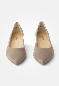 Ballerines beiges en daim à bout pointu avec une texture lisse et un design minimaliste. Présentent un empeigne légèrement courbée et une semelle plate.