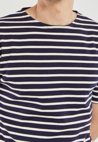 Navy and white striped cotton t-shirt with a round neckline; features short sleeves and a soft texture. Horizontal stripes are evenly spaced.