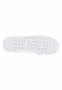 Sole di sneaker bianche in materiale gommoso, con un motivo di battistrada testurizzato per aderenza e stabilità. Finitura liscia con dettagli circolari e ondulati.