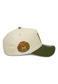 Baseballkappe in Creme mit grünem Schirm. Mit einem gestickten goldenen und blauen "World Series"-Patch an der Seite. Sechsteiliges Design.