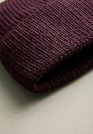 Strickmütze in tiefburgunderrot mit gerippter Textur. Der Stoff sieht weich und warm aus und hat ein umgeschlagenes Bündchen-Design.