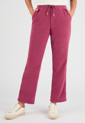 Fleece jogpants in donkerroze met een trekkoord in de taille, zijzakken en een relaxte pasvorm. Glad textuur en recht model.