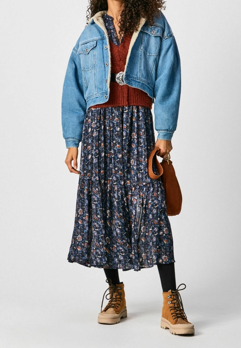 Jeansjacka, stickad rostfärgad tröja, blommig marinblå klänning, brun handväska och ljusbruna snörboots med platåsålar.