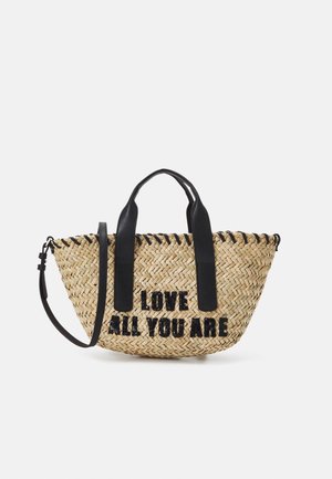 Geweven stro tote tas met zwarte handvatten en riem, voorzien van zwarte pailletten tekst "LOVE ALL YOU ARE" aan de voorkant.
