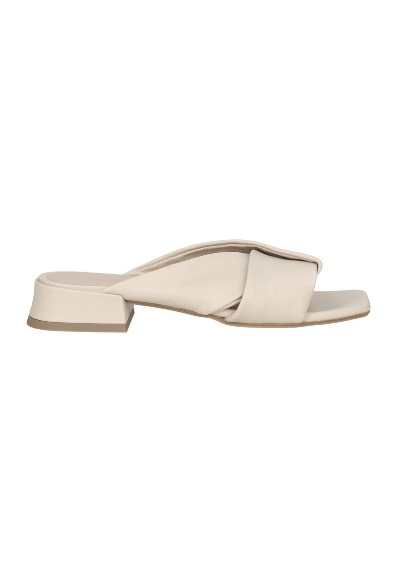 Beige leather slide sandal with a knotted design and a square toe. Features a low block heel and a smooth texture.