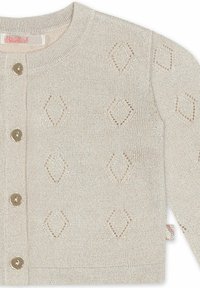 Cardigan beige tricoté avec des motifs en losange découpés, cinq boutons ronds beiges et une étiquette tissée en bas. Texture douce et col côtelé.