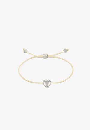 Verstellbares Armband mit einem zentralen silbernen Herzanhänger auf einem cremefarbenen Band, versehen mit kleineren silbernen Herzakzenten an den Enden.
