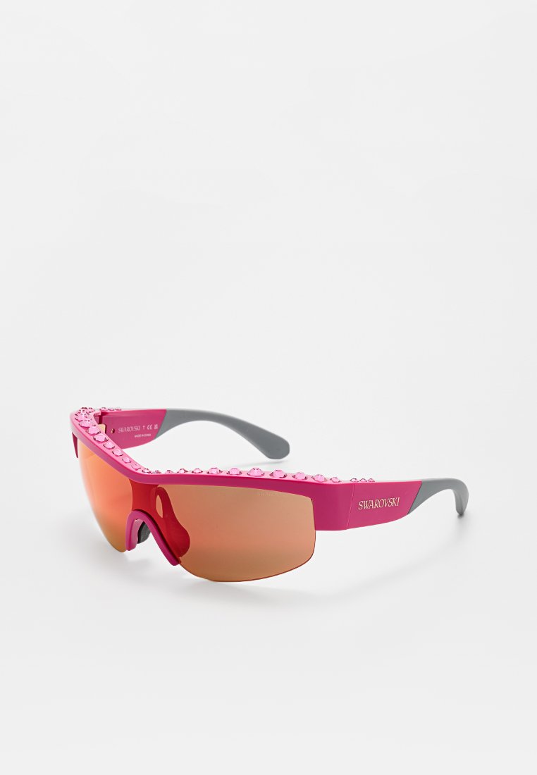 Lunettes de sport roses avec des branches grises, présentant une monture lisse, des verres miroités et des détails embellis le long du bord supérieur.