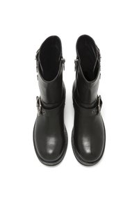 Stivali ankle in pelle nera con finitura liscia, cerniere laterali e dettagli in fibbia. Punta arrotondata e suola robusta e testurizzata.