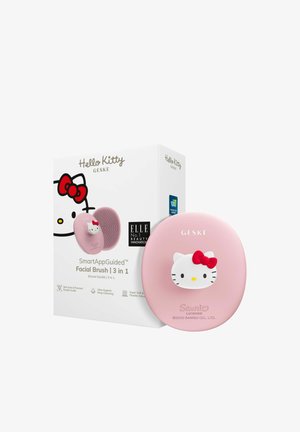 Brosse faciale intelligente Hello Kitty en silicone rose clair avec accent de nœud rouge ; l'emballage présente un design graphique et des informations sur le produit.