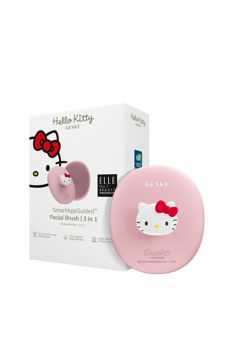 Brosse faciale intelligente Hello Kitty en silicone rose clair avec accent de nœud rouge ; l'emballage présente un design graphique et des informations sur le produit.