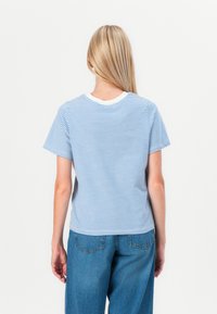 Blå och vit randig t-shirt med korta ärmar och rundad halsringning. Har en enfärgad vit krage och en avslappnad passform.