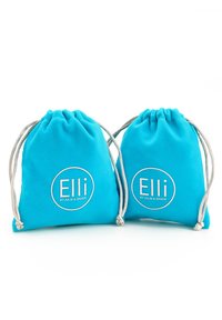 Deux sacs en tissu turquoise à cordon de serrage avec des accents en cordon argenté et un logo blanc circulaire arborant "Elli par Julie & Grace." Texture douce.