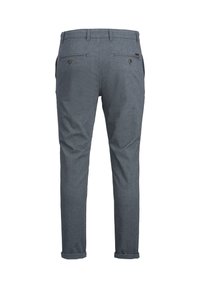 Pantalon gris coupe ajustée pour homme avec revers retroussés, comprenant des poches passepoilées boutonnées à l'arrière et des passants pour ceinture.