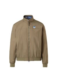 Giacca bomber color khaki con colletto alto, zip frontale, polsini e vita a costine. Presenta un logo rotondo blu sul lato sinistro del petto.