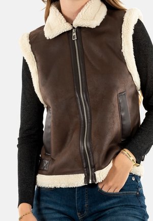 Braun synthetic Lederweste mit cremefarbener Schafwollkragen und -saum. Verfügt über seitliche Taschen und einen zentralen Reißverschluss. Texturierte Oberfläche und glatte Verarbeitung.