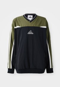 Adidas-pullover i svart och olivgrönt, med v-ringning, vita detaljer och en logotyp i mitten. Tillverkad av lätt material.