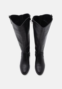 Bottes noires montantes en cuir lisse, avec un bout arrondi et des fermetures éclair latérales discrètes. La tige présente un design épuré sans motifs visibles.