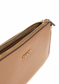 Pochette synthétique texturée marron avec fermeture éclair dorée et détail de logo. Forme rectangulaire compacte, adaptée aux essentiels.