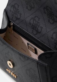 Borsa nera realizzata in materiale testurizzato, con una tasca interna con zip, dettagli in oro e accenti del logo su una fodera di colore chiaro.