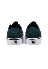 Green suede skate shoes with a padded collar, white rubber sole, and black accents featuring the DC logo on the heel.
