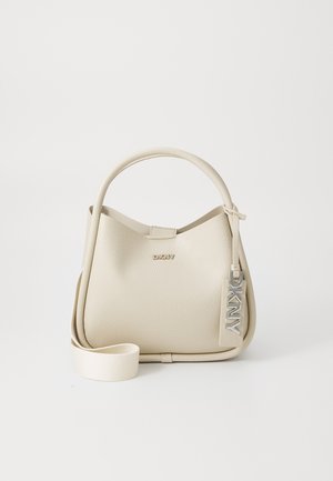 Bolso de mano de cuero beige texturizado con asa superior, correa de hombro desmontable y colgante metálico con el logo de DKNY en el lateral.